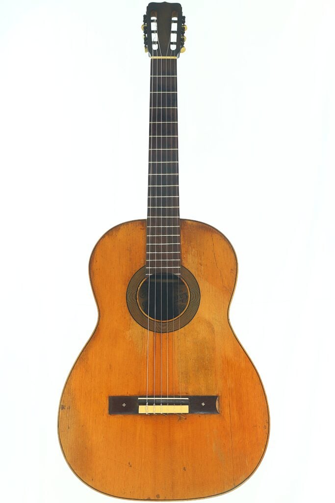 Die José Ramirez 1932 Klassische Gitarre mit Holzkorpus, sechs Saiten und einem dunklen Griffbrett wird vor einem schlichten weißen Hintergrund präsentiert. Die José Ramirez 1932 Klassische Gitarre mit Holzkorpus, sechs Saiten und einem dunklen Griffbrett wird vor einem schlichten weißen Hintergrund präsentiert.