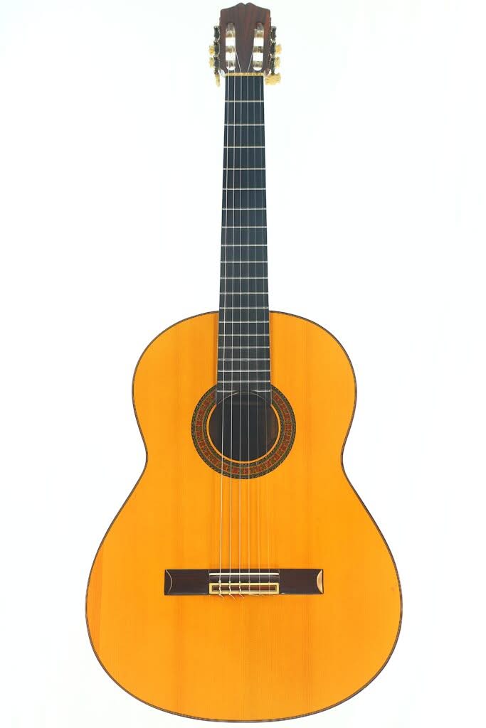 Sobrinos de Santos Hernandez 1974 Flamenco Gitarre – legendäre Flamenca aus der Werkstatt von Santos Hernández voller Charakter Die Flamenco-Gitarre „Sobrinos de Santos Hernandez 1974“ verfügt über einen Holzkorpus, ein dunkles Griffbrett, sechs Saiten und eine dekorative Rosette um das Schallloch, abgebildet vor weißem Hintergrund.