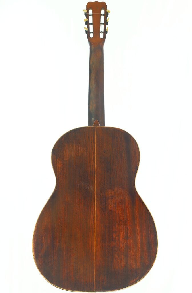 Die Rückansicht der José Ramirez 1932 Klassische Gitarre, bei der der Holzkorpus, der Hals und der Kopf mit den Stimmwirbeln vor einem weißen Hintergrund besonders gut zur Geltung kommen. Die Rückansicht der José Ramirez 1932 Klassische Gitarre, bei der der Holzkorpus, der Hals und der Kopf mit den Stimmwirbeln vor einem weißen Hintergrund besonders gut zur Geltung kommen.