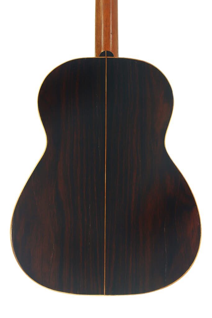 Der Boden der Salvador Ibanez 1900 Klassische Gitarre besteht aus dunklem Holz mit einer markanten Maserung, einer schmalen Einlage in der Mitte und einer hellen Umrandung an den Kanten. Der Boden der Salvador Ibanez 1900 Klassische Gitarre besteht aus dunklem Holz mit einer markanten Maserung, einer schmalen Einlage in der Mitte und einer hellen Umrandung an den Kanten.