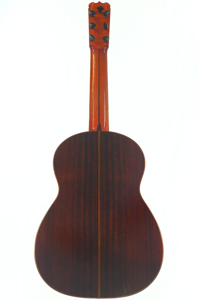 Hier ist der überarbeitete Satz unter Einbeziehung Ihrer Produktdaten: Die Rückansicht der „Melchor Rodriguez 1980 Ramirez Stil“ 7-saitigen klassischen Gitarre, die ihre dunkle Holzoberfläche und die sichtbare Mittelnaht zeigt, fotografiert vor einem schlichten weißen Hintergrund. Hier ist der überarbeitete Satz unter Einbeziehung Ihrer Produktdaten: Die Rückansicht der „Melchor Rodriguez 1980 Ramirez Stil“ 7-saitigen klassischen Gitarre, die ihre dunkle Holzoberfläche und die sichtbare Mittelnaht zeigt, fotografiert vor einem schlichten weißen Hintergrund.
