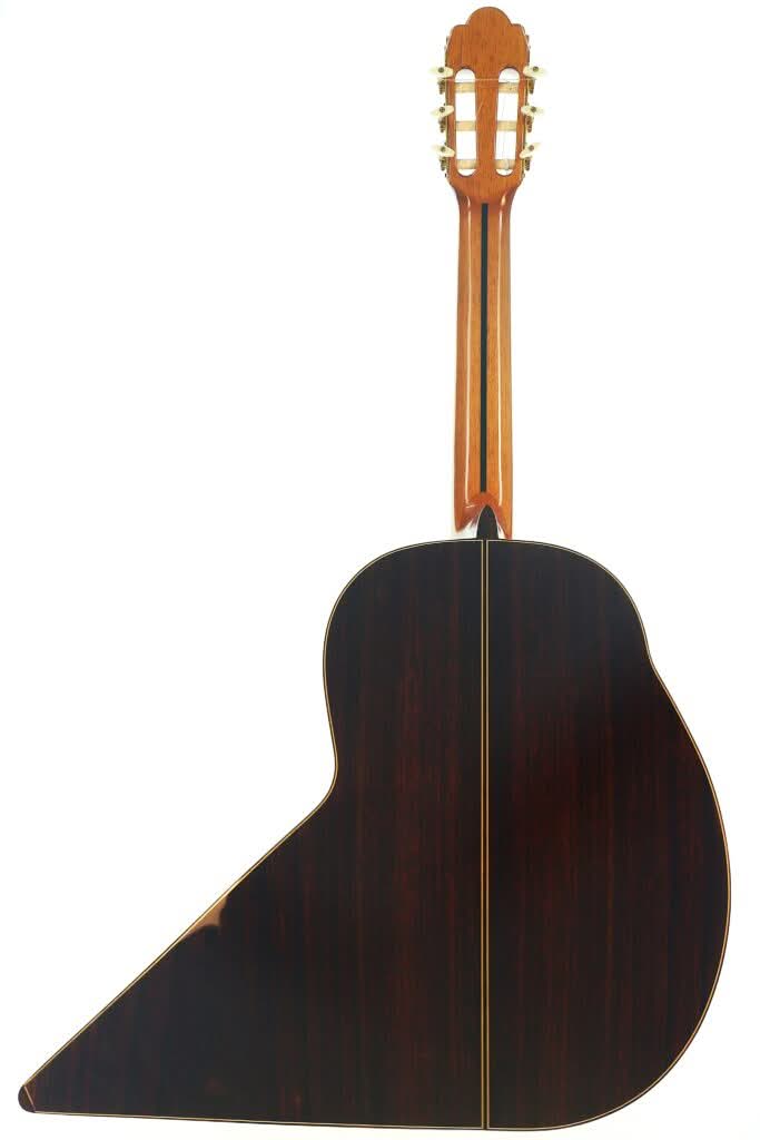 Die „Gran Klassische Gitarre“ von Raimundo und Aparicio Corujo, von hinten betrachtet: Sie besticht durch ihre markante asymmetrische Korpusform mit dunkler Holzoberfläche und einer geraden Mittelnaht. Die „Gran Klassische Gitarre“ von Raimundo und Aparicio Corujo, von hinten betrachtet: Sie besticht durch ihre markante asymmetrische Korpusform mit dunkler Holzoberfläche und einer geraden Mittelnaht.