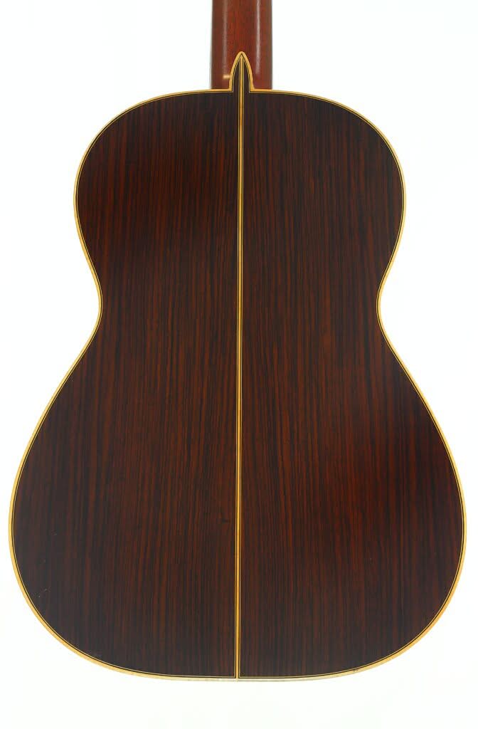 Die Rückseite der Alastair McNeil Hauser Klassische Gitarre aus dem Jahr 1997 weist eine dunkle Holzmaserung, eine gelbe Mittelnaht und eine gelbe Einfassung auf, die die Form umrandet. Die Rückseite der Alastair McNeil Hauser Klassische Gitarre aus dem Jahr 1997 weist eine dunkle Holzmaserung, eine gelbe Mittelnaht und eine gelbe Einfassung auf, die die Form umrandet.