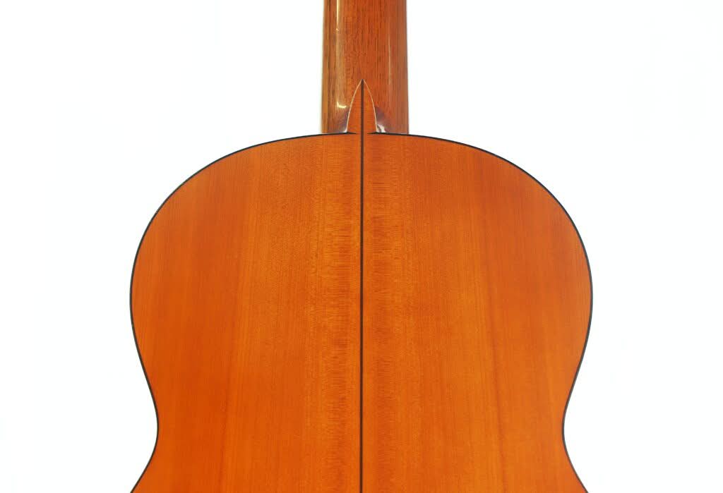 Nahaufnahme der Rückseite einer Jose Ramirez 1a Flamenco-Gitarre aus dem Jahr 1968 vor weißem Hintergrund, wobei die Holzmaserung und die Fuge zwischen zwei Holzstücken besonders hervorgehoben werden. Nahaufnahme der Rückseite einer Jose Ramirez 1a Flamenco-Gitarre aus dem Jahr 1968 vor weißem Hintergrund, wobei die Holzmaserung und die Fuge zwischen zwei Holzstücken besonders hervorgehoben werden.