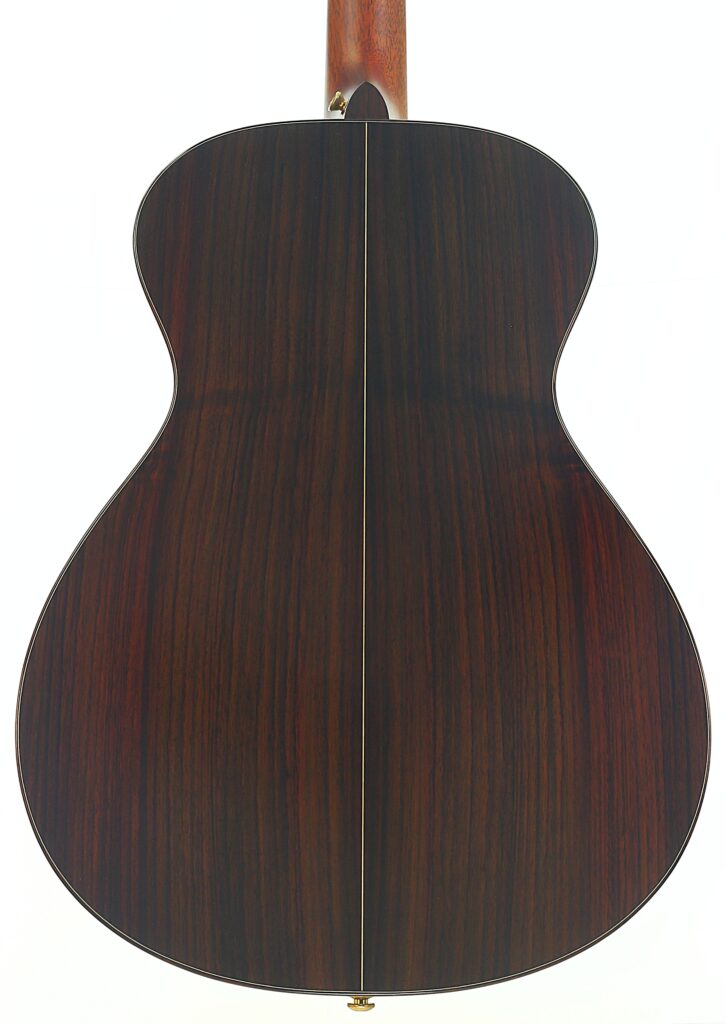 Die Rückseite der Taylor 712 Akustikgitarre ist mit einer dunklen, polierten Holzoberfläche versehen, die durch eine schmale, helle Linie akzentuiert wird, die vertikal in der Mitte verläuft. Die Rückseite der Taylor 712 Akustikgitarre ist mit einer dunklen, polierten Holzoberfläche versehen, die durch eine schmale, helle Linie akzentuiert wird, die vertikal in der Mitte verläuft.