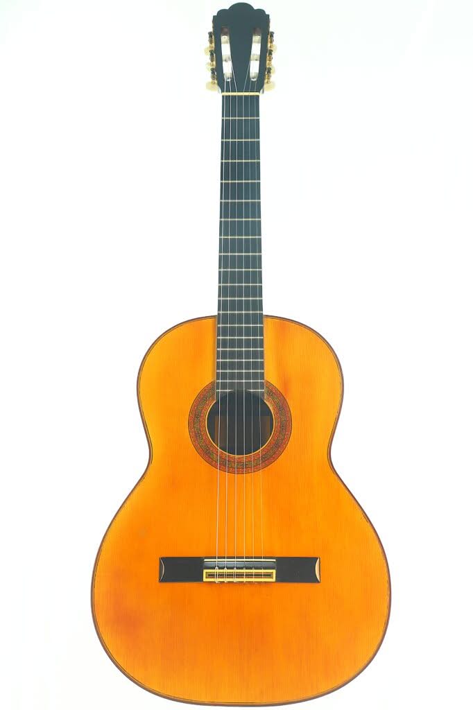 Die Juan Estruch 1971 Chet Atkins Klassische Gitarre ist eine klassische Akustikgitarre mit einem Holzkorpus, sechs Saiten, einem dunklen Griffbrett und einer dekorativen Rosette, die vor einem weißen Hintergrund abgebildet ist. Die Juan Estruch 1971 Chet Atkins Klassische Gitarre ist eine klassische Akustikgitarre mit einem Holzkorpus, sechs Saiten, einem dunklen Griffbrett und einer dekorativen Rosette, die vor einem weißen Hintergrund abgebildet ist.