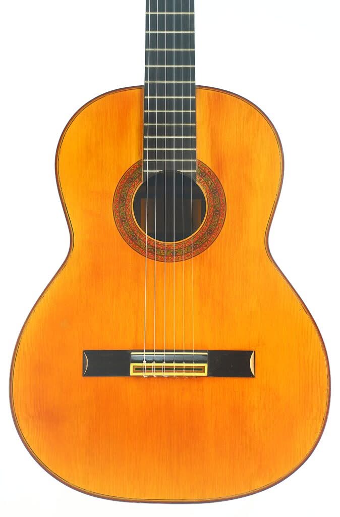 Die „Juan Estruch 1971 Chet Atkins Klassische Gitarre“ ist eine klassische Akustikgitarre mit einem Holzkorpus, einem dunklen Griffbrett, sechs Saiten und einer dekorativen Rosette um das Schallloch, abgebildet auf weißem Hintergrund. Die „Juan Estruch 1971 Chet Atkins Klassische Gitarre“ ist eine klassische Akustikgitarre mit einem Holzkorpus, einem dunklen Griffbrett, sechs Saiten und einer dekorativen Rosette um das Schallloch, abgebildet auf weißem Hintergrund.