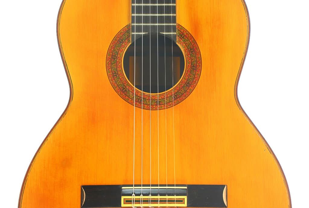 Nahaufnahme des Korpus der „Juan Estruch 1971 Chet Atkins Klassische Gitarre“, die die sechs Saiten, die verzierte Schalllochrosette und die Holzmaserung vor weißem Hintergrund hervorhebt. Nahaufnahme des Korpus der „Juan Estruch 1971 Chet Atkins Klassische Gitarre“, die die sechs Saiten, die verzierte Schalllochrosette und die Holzmaserung vor weißem Hintergrund hervorhebt.
