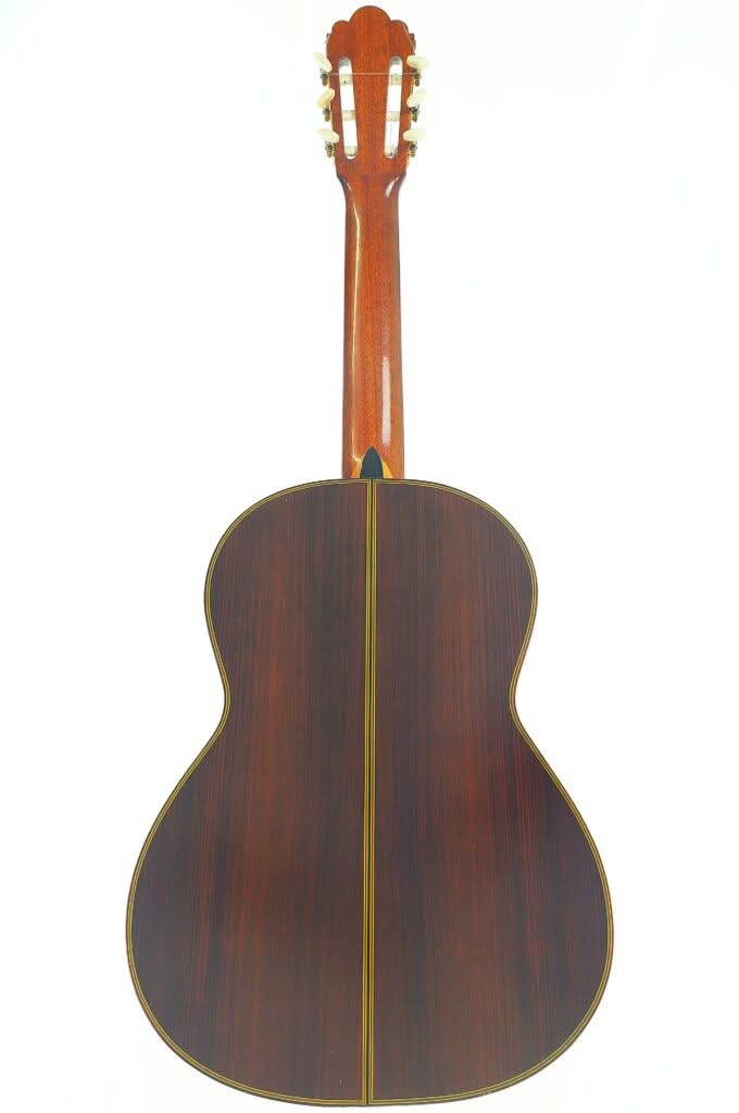 Rückansicht der Juan Estruch 1971 Chet Atkins Klassische Gitarre mit dunkler Holzoberfläche, gelber Seitenumrandung und sichtbaren Stimmwirbeln am oberen Ende. Rückansicht der Juan Estruch 1971 Chet Atkins Klassische Gitarre mit dunkler Holzoberfläche, gelber Seitenumrandung und sichtbaren Stimmwirbeln am oberen Ende.