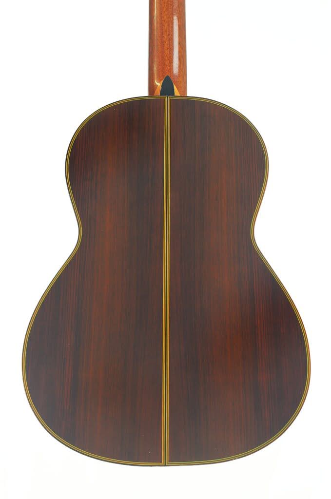 Die Rückseite einer „Chet Atkins Klassische Gitarre“ von Juan Estruch aus dem Jahr 1971, die sich durch dunkles Holz mit einer sichtbaren Mittelnaht und gelber Einfassung auszeichnet, fotografiert vor weißem Hintergrund. Die Rückseite einer „Chet Atkins Klassische Gitarre“ von Juan Estruch aus dem Jahr 1971, die sich durch dunkles Holz mit einer sichtbaren Mittelnaht und gelber Einfassung auszeichnet, fotografiert vor weißem Hintergrund.