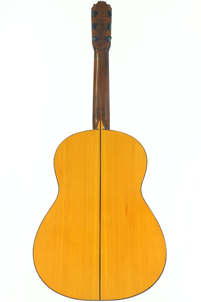 Rückansicht der Jose de Jesus 2024 Blanca Modell Reyes Flamenco-Gitarre mit einem Korpus aus hellem Holz, einem Hals aus dunklem Holz und einer sichtbaren Mittelnaht, die vertikal über den Rücken verläuft. Rückansicht der Jose de Jesus 2024 Blanca Modell Reyes Flamenco-Gitarre mit einem Korpus aus hellem Holz, einem Hals aus dunklem Holz und einer sichtbaren Mittelnaht, die vertikal über den Rücken verläuft.