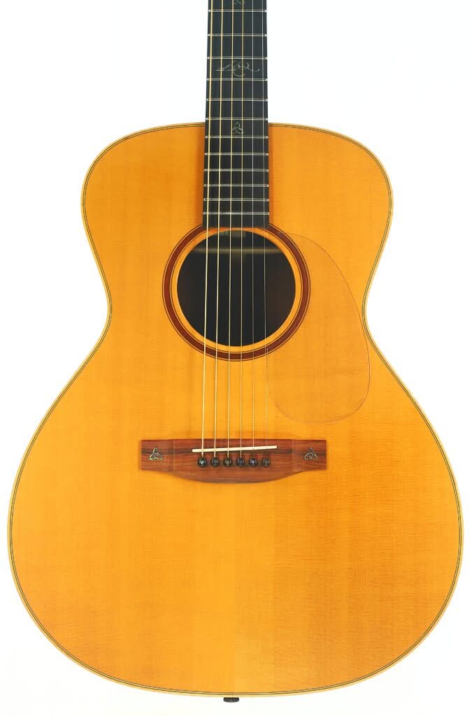 Die Akustikgitarre Lakewood M-54 1998 zeichnet sich durch eine naturbelassene Holzoberfläche, sechs Saiten, ein dunkles, rundes Schallloch und elegante Details aus. Das Bild zeigt den Korpus und den unteren Hals vor einem weißen Hintergrund. Die Akustikgitarre Lakewood M-54 1998 zeichnet sich durch eine naturbelassene Holzoberfläche, sechs Saiten, ein dunkles, rundes Schallloch und elegante Details aus. Das Bild zeigt den Korpus und den unteren Hals vor einem weißen Hintergrund.