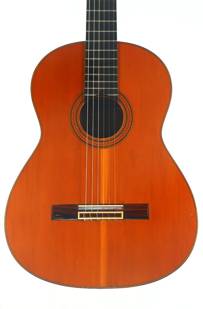 Antonio Duran, 1974, klassische Gitarre mit Holzkorpus, sechs Saiten, dunklem Griffbrett und aufwendig gestaltetem Rosettenmuster um das Schallloch, fotografiert vor weißem Hintergrund. Antonio Duran, 1974, klassische Gitarre mit Holzkorpus, sechs Saiten, dunklem Griffbrett und aufwendig gestaltetem Rosettenmuster um das Schallloch, fotografiert vor weißem Hintergrund.