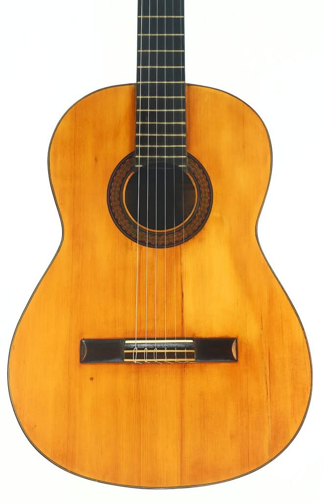 Die Modesto Borreguero 1955 ist eine klassische Akustikgitarre mit einem Holzkorpus, einem dunklen Griffbrett und sechs Saiten, die vor einem schlichten weißen Hintergrund abgebildet ist. Die Modesto Borreguero 1955 ist eine klassische Akustikgitarre mit einem Holzkorpus, einem dunklen Griffbrett und sechs Saiten, die vor einem schlichten weißen Hintergrund abgebildet ist.