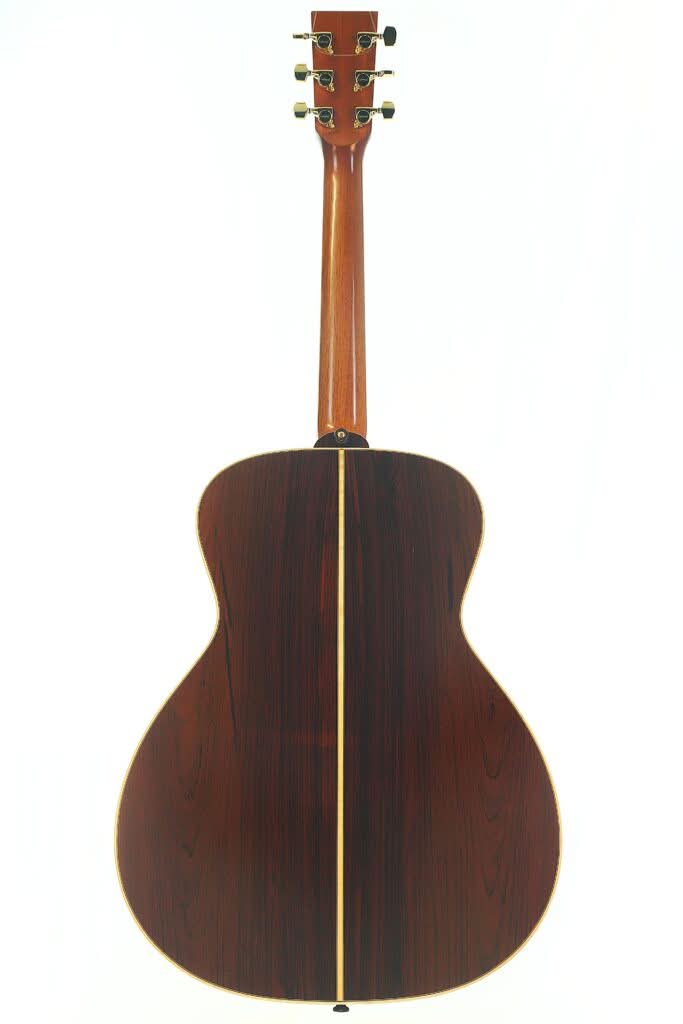 Die Rückansicht der Lakewood M-54 Akustikgitarre aus dem Jahr 1998 zeigt den Holzkorpus, die Mittelnaht, die Stimmwirbel, die glatte, glänzende Lackierung und die markanten Holzmaserungen. Die Rückansicht der Lakewood M-54 Akustikgitarre aus dem Jahr 1998 zeigt den Holzkorpus, die Mittelnaht, die Stimmwirbel, die glatte, glänzende Lackierung und die markanten Holzmaserungen.