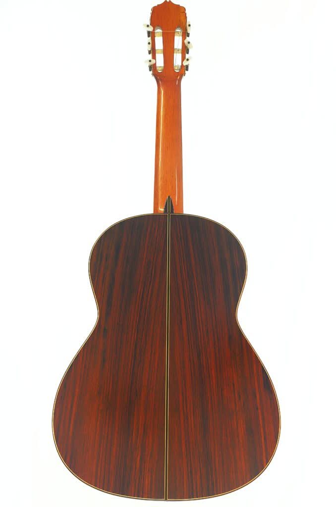 Die klassische Gitarre „Antonio Duran 1974“ ist von hinten abgebildet und besticht durch dunkles Holz mit einer mittigen Naht sowie hellen Zierleisten an den Rändern. Oben sind der Hals und die Stimmwirbel vor einem schlichten weißen Hintergrund zu sehen. Die klassische Gitarre „Antonio Duran 1974“ ist von hinten abgebildet und besticht durch dunkles Holz mit einer mittigen Naht sowie hellen Zierleisten an den Rändern. Oben sind der Hals und die Stimmwirbel vor einem schlichten weißen Hintergrund zu sehen.