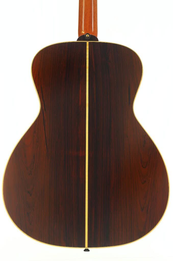 Die Lakewood M-54 Akustikgitarre aus dem Jahr 1998 verfügt über einen Korpus aus dunklem, poliertem Holz mit einem markanten vertikalen hellen Streifen in der Mitte, abgerundeten Kanten und sichtbarer Holzmaserung, was ihr ein edles Erscheinungsbild verleiht. Die Lakewood M-54 Akustikgitarre aus dem Jahr 1998 verfügt über einen Korpus aus dunklem, poliertem Holz mit einem markanten vertikalen hellen Streifen in der Mitte, abgerundeten Kanten und sichtbarer Holzmaserung, was ihr ein edles Erscheinungsbild verleiht.