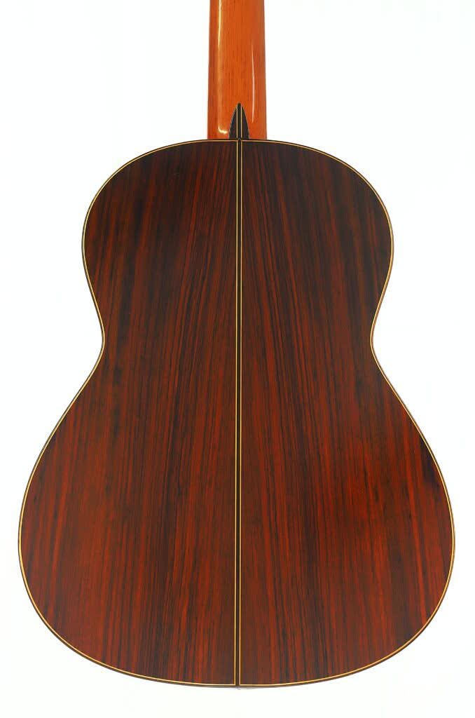 Die Rückseite der „Klassische Gitarre“ von Antonio Duran aus dem Jahr 1974, gefertigt aus dunklem, poliertem Holz mit einer geraden, vertikalen Mittelnaht, vor weißem Hintergrund. Die Rückseite der „Klassische Gitarre“ von Antonio Duran aus dem Jahr 1974, gefertigt aus dunklem, poliertem Holz mit einer geraden, vertikalen Mittelnaht, vor weißem Hintergrund.