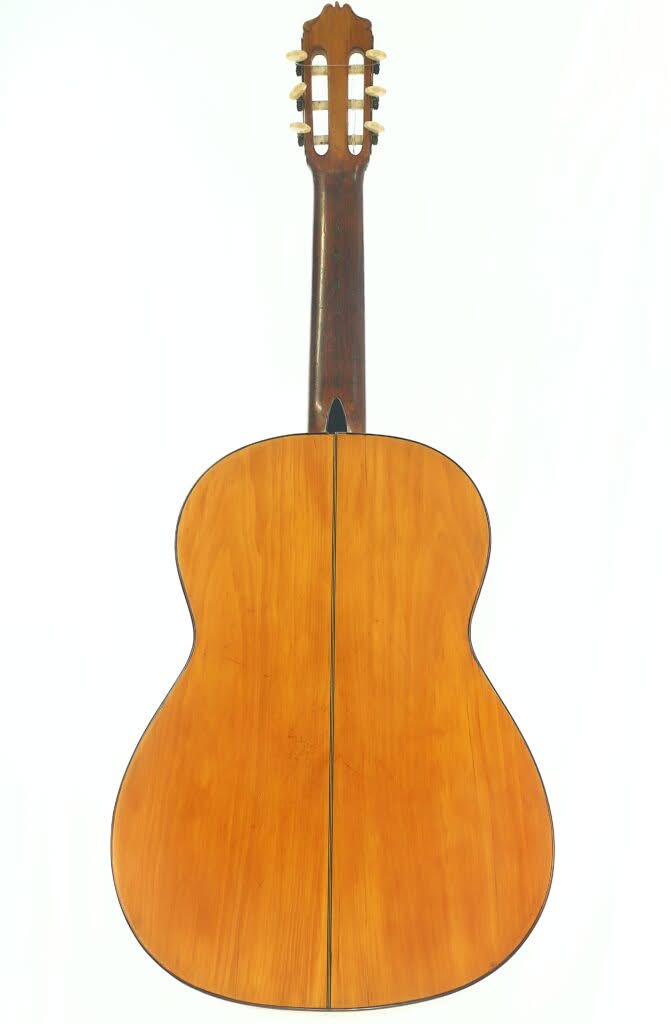 Das Bild zeigt die Rückseite einer klassischen Akustikgitarre von Modesto Borreguero aus dem Jahr 1955 mit Holzoberfläche, Mittelnaht sowie dunklem Hals und dunklen Stimmwirbeln. Das Bild zeigt die Rückseite einer klassischen Akustikgitarre von Modesto Borreguero aus dem Jahr 1955 mit Holzoberfläche, Mittelnaht sowie dunklem Hals und dunklen Stimmwirbeln.
