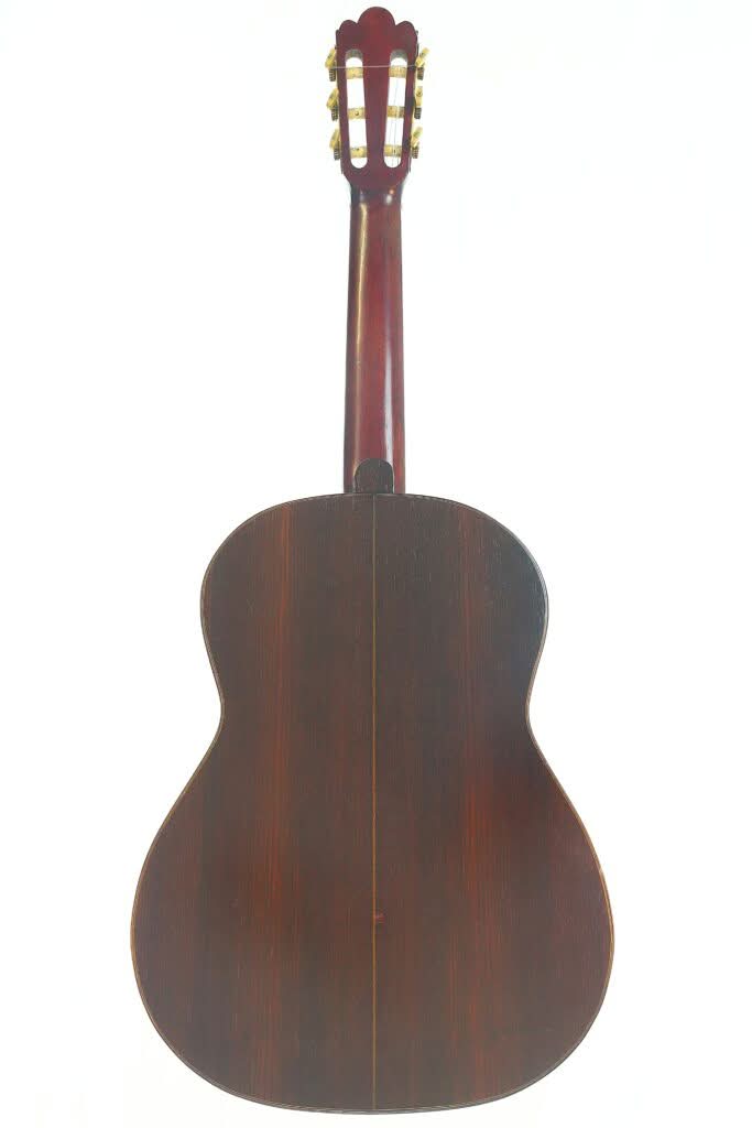 Die klassische Gitarre „Francisco Simplicio 1931 Torres“ ist von hinten abgebildet, wobei ihr Korpus und Hals aus dunklem Holz sowie die goldenen Stimmwirbel vor einem weißen Hintergrund besonders zur Geltung kommen. Die klassische Gitarre „Francisco Simplicio 1931 Torres“ ist von hinten abgebildet, wobei ihr Korpus und Hals aus dunklem Holz sowie die goldenen Stimmwirbel vor einem weißen Hintergrund besonders zur Geltung kommen.