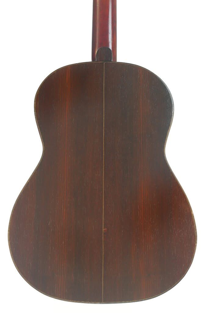 Die Rückseite der Francisco Simplicio 1931 Torres Klassische Gitarre besteht aus dunklem Holz mit einer eleganten vertikalen Mittelnaht und einer glatten, polierten Oberfläche. Die Rückseite der Francisco Simplicio 1931 Torres Klassische Gitarre besteht aus dunklem Holz mit einer eleganten vertikalen Mittelnaht und einer glatten, polierten Oberfläche.