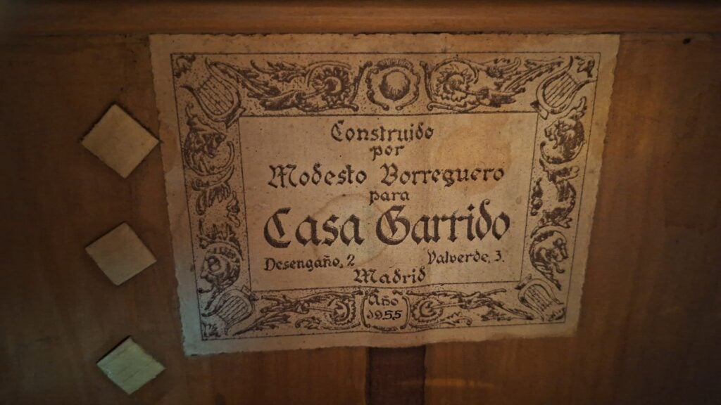 Auf einem alten Holzschild von Modesto Borreguero aus dem Jahr 1955 steht: „Construido por Modesto Borreguero 1955 para Casa Garrido, Desengaño, 2 Valverde, 3, Madrid“, umrahmt von Blumenornamenten und drei Rauten auf der linken Seite. Auf einem alten Holzschild von Modesto Borreguero aus dem Jahr 1955 steht: „Construido por Modesto Borreguero 1955 para Casa Garrido, Desengaño, 2 Valverde, 3, Madrid“, umrahmt von Blumenornamenten und drei Rauten auf der linken Seite.