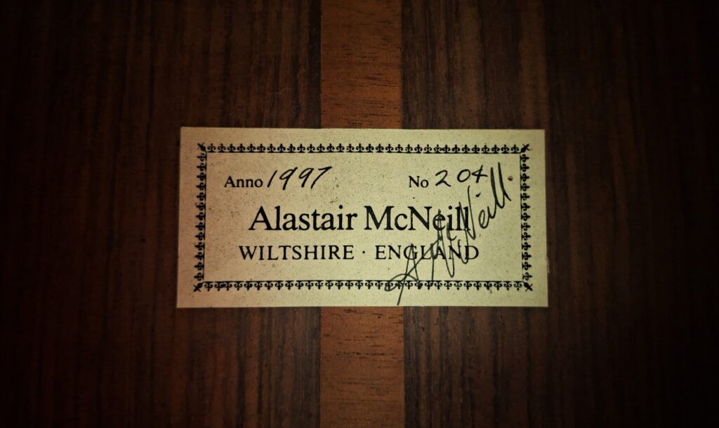 Auf einem Etikett der „Hauser Klassische Gitarre“ von Alastair McNeil aus dem Jahr 1997 steht: „Anno 1997, Nr. 204, Alastair McNeill, Wiltshire, England“, ergänzt durch eine mit schwarzer Tinte geschriebene Unterschrift. Auf einem Etikett der „Hauser Klassische Gitarre“ von Alastair McNeil aus dem Jahr 1997 steht: „Anno 1997, Nr. 204, Alastair McNeill, Wiltshire, England“, ergänzt durch eine mit schwarzer Tinte geschriebene Unterschrift.