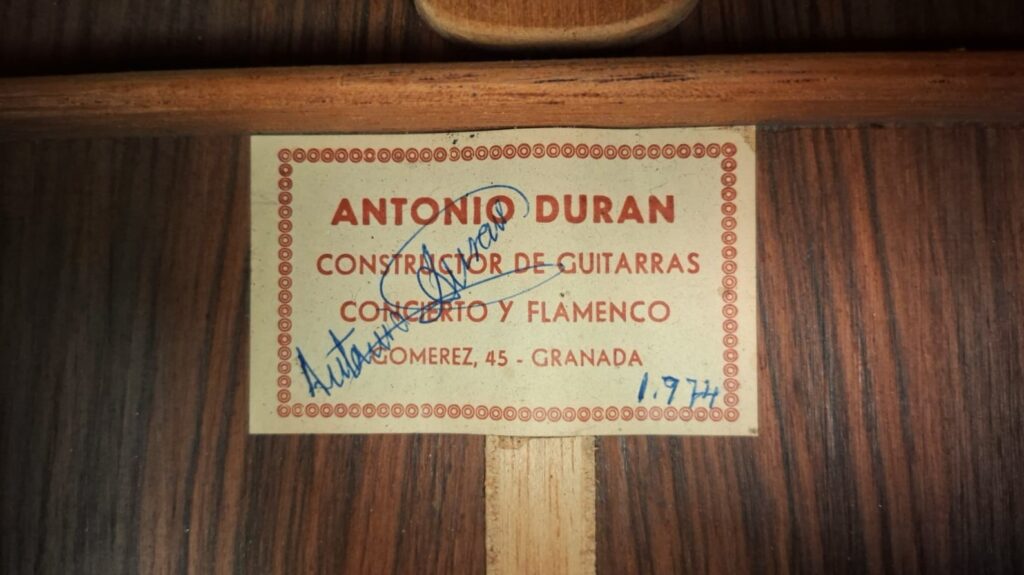 Auf dem Etikett der „Antonio Duran 1974 Klassische Gitarre“ steht: „Antonio Duran, Constructor de Guitarras, Concierto y Flamenco, Lomezez, 45 – Granada“, ergänzt durch eine Unterschrift und die handschriftliche Angabe „1974“ in blauer Tinte. Auf dem Etikett der „Antonio Duran 1974 Klassische Gitarre“ steht: „Antonio Duran, Constructor de Guitarras, Concierto y Flamenco, Lomezez, 45 – Granada“, ergänzt durch eine Unterschrift und die handschriftliche Angabe „1974“ in blauer Tinte.