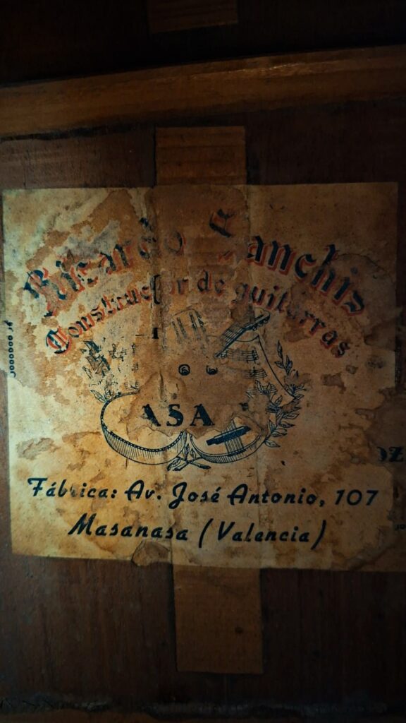 Auf einem abgenutzten Etikett an der Gitarre steht: „Blasco Sanchis, Constructor de guitarras, ASA, Fábrica: Av. José Antonio, 107, Masanasa (Valencia).“ Dieses gealterte und fleckige Etikett – mit teilweise verblasstem Text – befindet sich auf der „Ricardo Sanchis Nacher 1940 Augustin Barrios Klassische Gitarre“. Auf einem abgenutzten Etikett an der Gitarre steht: „Blasco Sanchis, Constructor de guitarras, ASA, Fábrica: Av. José Antonio, 107, Masanasa (Valencia).“ Dieses gealterte und fleckige Etikett – mit teilweise verblasstem Text – befindet sich auf der „Ricardo Sanchis Nacher 1940 Augustin Barrios Klassische Gitarre“.