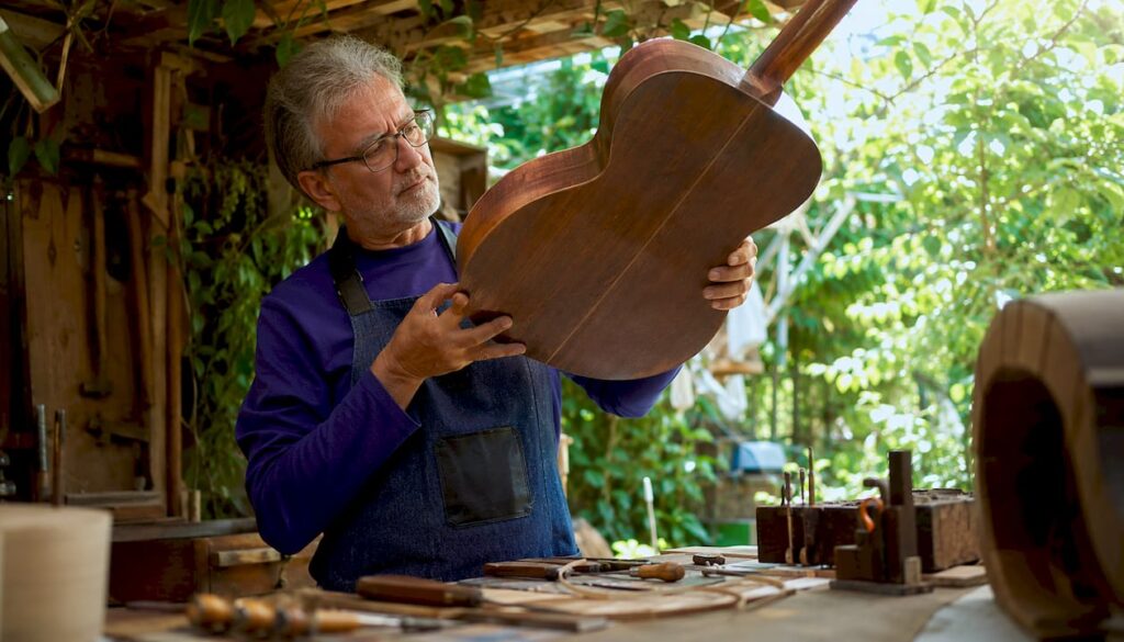 Luthier examining back and sides of vintage guitar