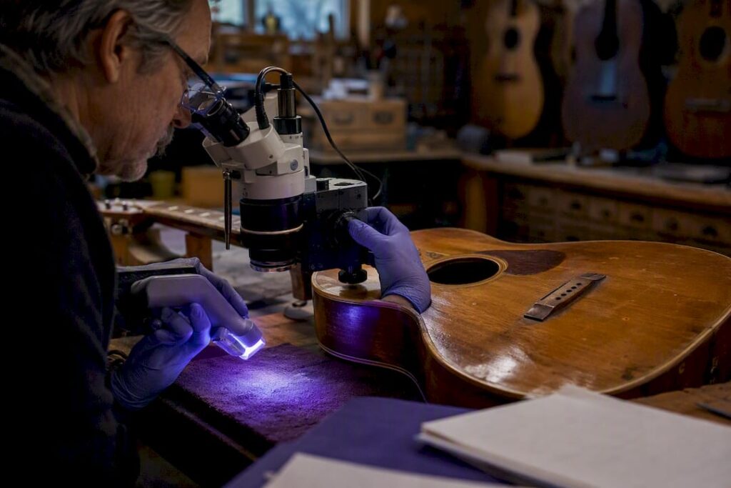 Gloved hands using forensic tools on guitar