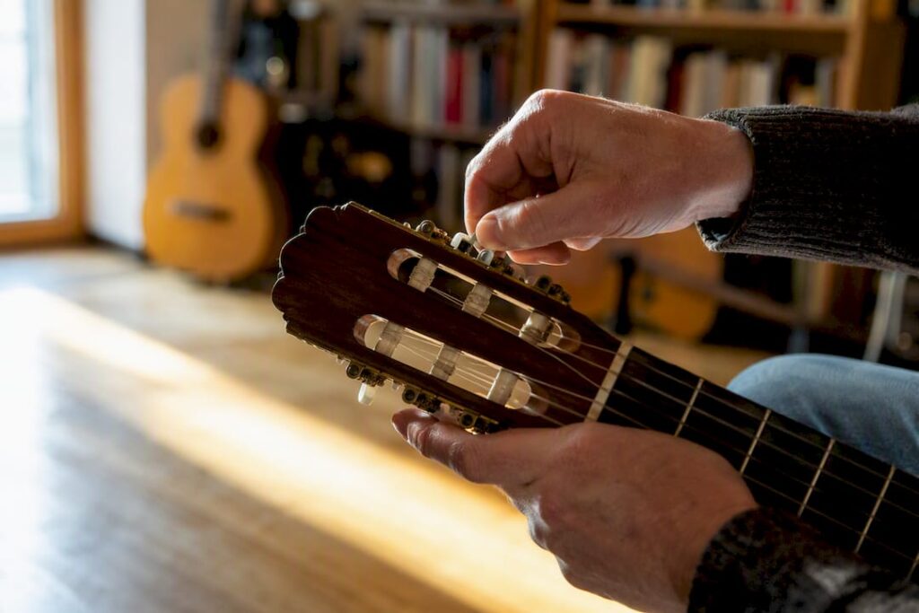 Hände stimmen zu Hause eine klassische Gitarre