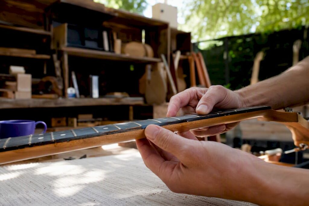 Luthier inspecting guitar neck closely