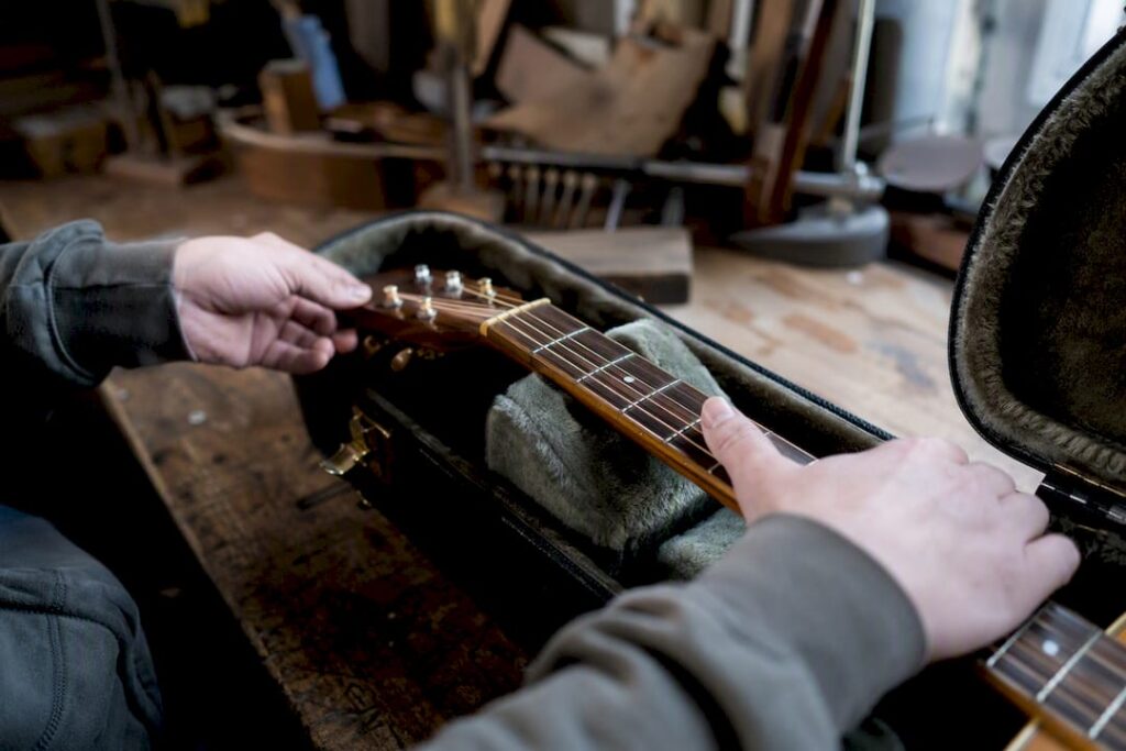 Hände prüfen, ob die Gitarre ins Hartschalenetui passt