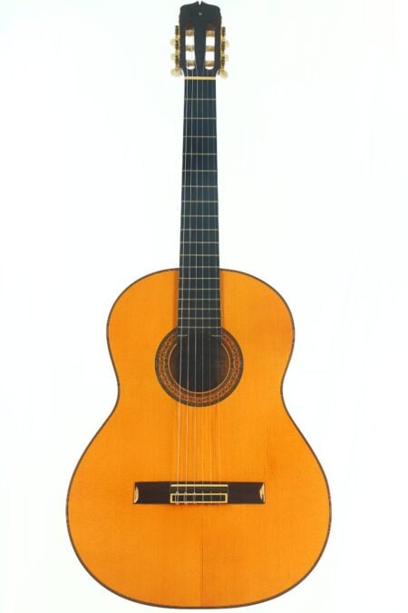 Die Gitarre „Manuel Reyes 1990 Estudio Flamenco“ verfügt über einen hellen Holzkorpus, ein dunkles Griffbrett, sechs Saiten und eine dekorative Rosette um das Schallloch, abgebildet vor einem schlichten weißen Hintergrund. Die Gitarre „Manuel Reyes 1990 Estudio Flamenco“ verfügt über einen hellen Holzkorpus, ein dunkles Griffbrett, sechs Saiten und eine dekorative Rosette um das Schallloch, abgebildet vor einem schlichten weißen Hintergrund.