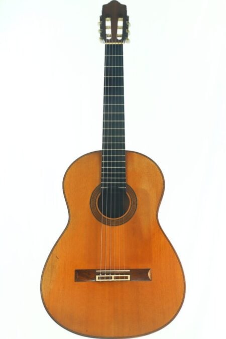 Eine Juan-Lopez-Aguilarte-Flamenco-Gitarre „Negra“ aus dem Jahr 1984 mit einem Holzkorpus, sechs Saiten und einem dunklen Griffbrett, fotografiert vor weißem Hintergrund. Eine Juan-Lopez-Aguilarte-Flamenco-Gitarre „Negra“ aus dem Jahr 1984 mit einem Holzkorpus, sechs Saiten und einem dunklen Griffbrett, fotografiert vor weißem Hintergrund.