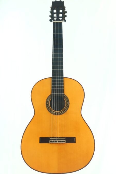 Eine Pena Vargas 2026 Negra Flamenco-Gitarre mit Holzkorpus, sechs Saiten, dunklem Griffbrett und einer aufwendig gestalteten Rosette um das Schallloch, fotografiert vor einem schlichten weißen Hintergrund.