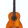 Eine klassische Gitarre von Telesforo Julve aus dem Jahr 1930 mit einem Korpus aus Holz, sechs Saiten und einer aufwendig gestalteten Rosette um das Schallloch, fotografiert vor weißem Hintergrund.