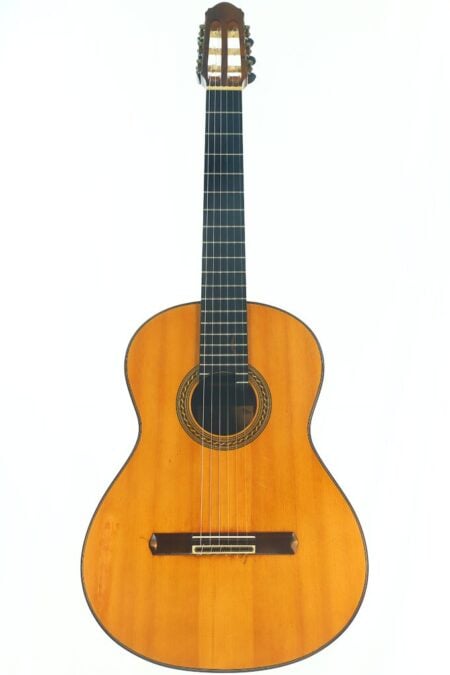 Eine Antonius Müller 2004 Doubletop Klassische Gitarre mit hellbraunem Holzkorpus, dunklem Griffbrett und sechs Nylonsaiten, aufrecht vor weißem Hintergrund fotografiert. Eine Antonius Müller 2004 Doubletop Klassische Gitarre mit hellbraunem Holzkorpus, dunklem Griffbrett und sechs Nylonsaiten, aufrecht vor weißem Hintergrund fotografiert.