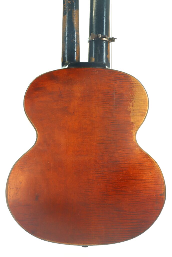 Die Rückseite einer Kontragitarre vom Typ „Stil 1900“ von Gustav Keller Stauffer, die ihre Vintage-Sunburst-Lackierung, die sichtbare Holzmaserung und Gebrauchsspuren zeigt, fotografiert im aufrechten Stand vor weißem Hintergrund. Die Rückseite einer Kontragitarre vom Typ „Stil 1900“ von Gustav Keller Stauffer, die ihre Vintage-Sunburst-Lackierung, die sichtbare Holzmaserung und Gebrauchsspuren zeigt, fotografiert im aufrechten Stand vor weißem Hintergrund.