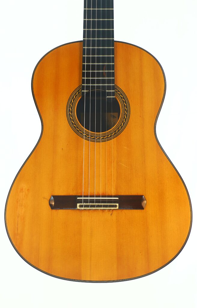 Die Antonius Müller 2004 Doubletop Klassische Gitarre mit Holzkorpus, sechs Saiten und einer aufwendig gestalteten Rosette um das Schallloch herum ist vor einem weißen Hintergrund abgebildet. Die Antonius Müller 2004 Doubletop Klassische Gitarre mit Holzkorpus, sechs Saiten und einer aufwendig gestalteten Rosette um das Schallloch herum ist vor einem weißen Hintergrund abgebildet.