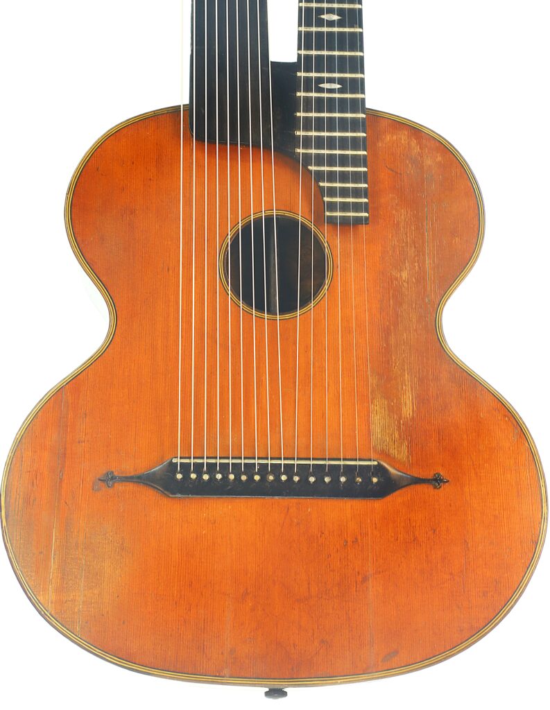 Eine Kontragitarre im Stil von Gustav Keller Stauffer aus dem Jahr 1900 mit einem Korpus aus Holz, einem Standard-Gitarrenhals und zusätzlichen, offenen Harfensaiten, die von der Decke ausgehen. Eine Kontragitarre im Stil von Gustav Keller Stauffer aus dem Jahr 1900 mit einem Korpus aus Holz, einem Standard-Gitarrenhals und zusätzlichen, offenen Harfensaiten, die von der Decke ausgehen.