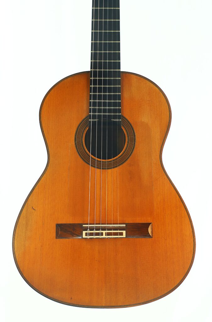 Eine Juan-Lopez-Aguilarte-Flamenco-Gitarre „Negra“ aus dem Jahr 1984 mit Holzkorpus, dunklem Griffbrett und sechs Saiten, fotografiert vor einem schlichten weißen Hintergrund. Eine Juan-Lopez-Aguilarte-Flamenco-Gitarre „Negra“ aus dem Jahr 1984 mit Holzkorpus, dunklem Griffbrett und sechs Saiten, fotografiert vor einem schlichten weißen Hintergrund.