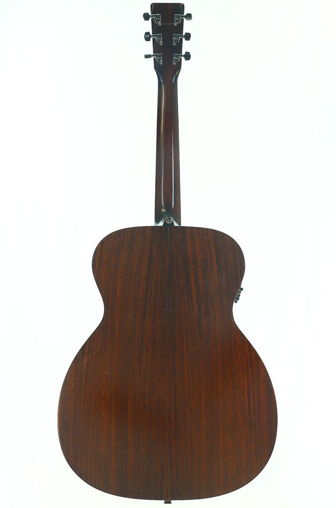 Die Rückansicht einer MARTIN OM-21 Akustikgitarre aus dem Jahr 1995 mit dunkler Holzoberfläche, auf der der Hals, die Stimmwirbel und die Holzmaserung vor weißem Hintergrund zu sehen sind. Die Rückansicht einer MARTIN OM-21 Akustikgitarre aus dem Jahr 1995 mit dunkler Holzoberfläche, auf der der Hals, die Stimmwirbel und die Holzmaserung vor weißem Hintergrund zu sehen sind.
