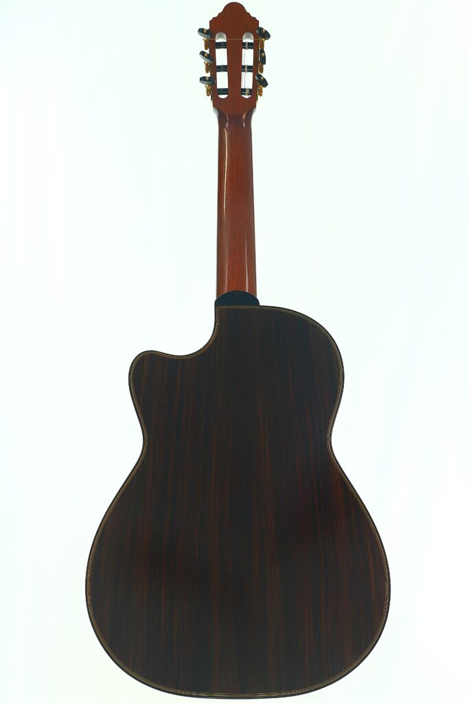 Die Antonius Müller 2012 Doubletop Klassische Gitarre ist von hinten abgebildet, wobei ihr dunkler Holzkorpus, der glatte Hals und die goldenen Stimmwirbel vor einem schlichten weißen Hintergrund besonders gut zur Geltung kommen. Die Antonius Müller 2012 Doubletop Klassische Gitarre ist von hinten abgebildet, wobei ihr dunkler Holzkorpus, der glatte Hals und die goldenen Stimmwirbel vor einem schlichten weißen Hintergrund besonders gut zur Geltung kommen.