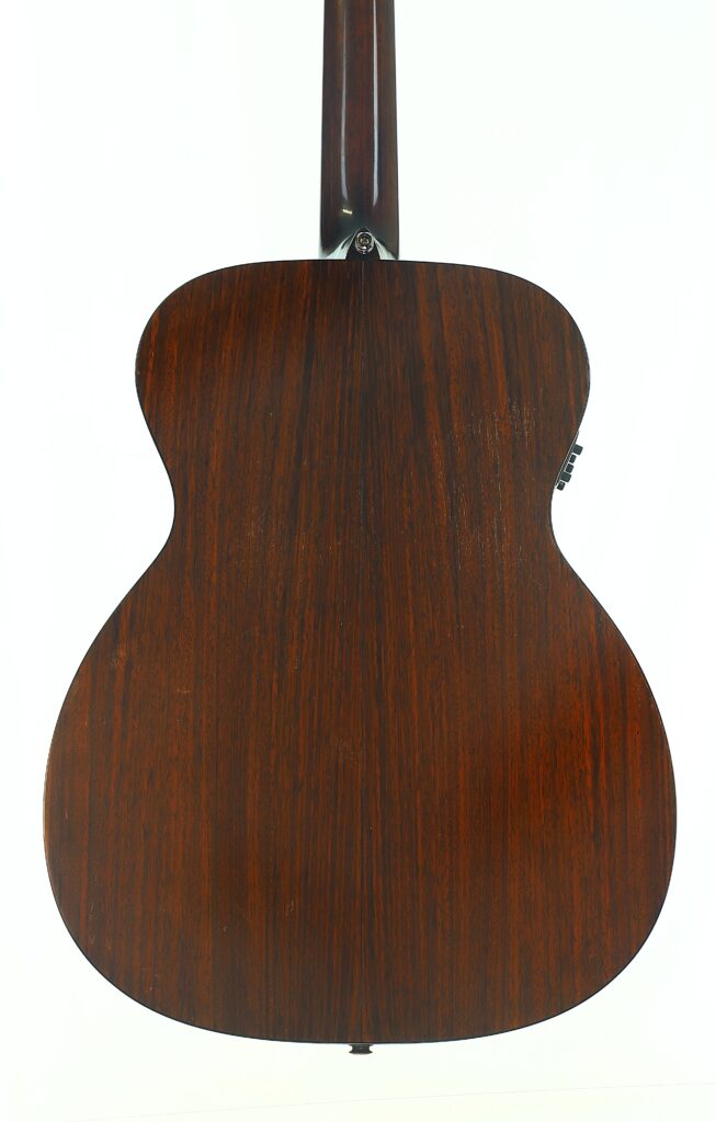 Das Bild zeigt die Rückseite einer MARTIN OM-21 Akustikgitarre aus dem Jahr 1995 mit einer dunklen, satten Holzmaserung vor einem schlichten weißen Hintergrund. Das Bild zeigt die Rückseite einer MARTIN OM-21 Akustikgitarre aus dem Jahr 1995 mit einer dunklen, satten Holzmaserung vor einem schlichten weißen Hintergrund.