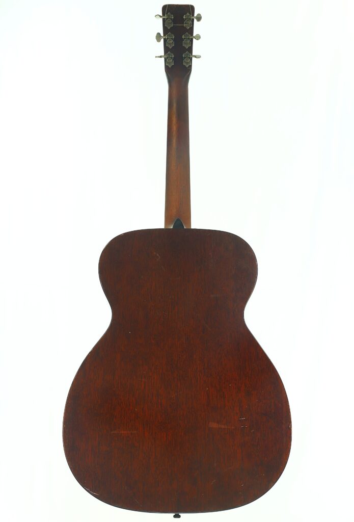 Die Rückansicht der Martin 000-18 Akustikgitarre aus dem Jahr 1960 mit dunkler Holzoberfläche, auf der der Korpus, der Hals und die Stimmwirbel vor einem schlichten weißen Hintergrund zu sehen sind. Die Rückansicht der Martin 000-18 Akustikgitarre aus dem Jahr 1960 mit dunkler Holzoberfläche, auf der der Korpus, der Hals und die Stimmwirbel vor einem schlichten weißen Hintergrund zu sehen sind.