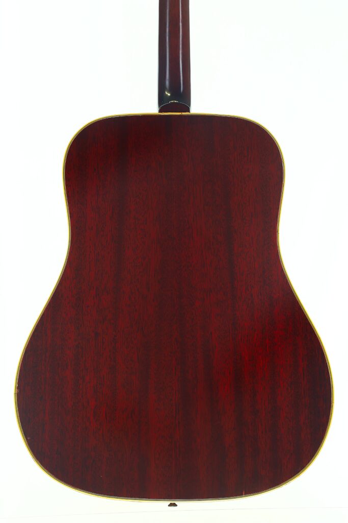 Die Rückansicht der Gibson SJN 1968 Akustikgitarre zeigt ihre satte, dunkle Holzoberfläche mit einem leicht glänzenden Finish, das die natürliche Maserung hervorhebt. Die Rückansicht der Gibson SJN 1968 Akustikgitarre zeigt ihre satte, dunkle Holzoberfläche mit einem leicht glänzenden Finish, das die natürliche Maserung hervorhebt.