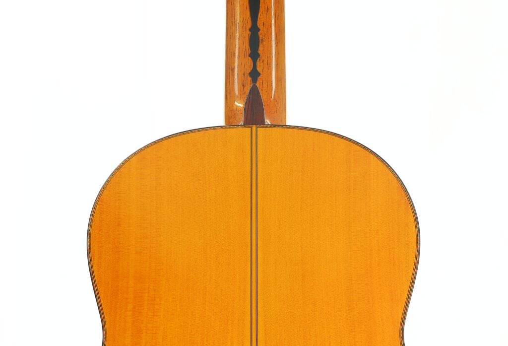 Die Rückseite der Flamenco-Gitarre „Jeronimo Pena 1976“ mit ihrem Holzkorpus und den Zierintarsien entlang der Mittelnaht vor weißem Hintergrund. Die Rückseite der Flamenco-Gitarre „Jeronimo Pena 1976“ mit ihrem Holzkorpus und den Zierintarsien entlang der Mittelnaht vor weißem Hintergrund.