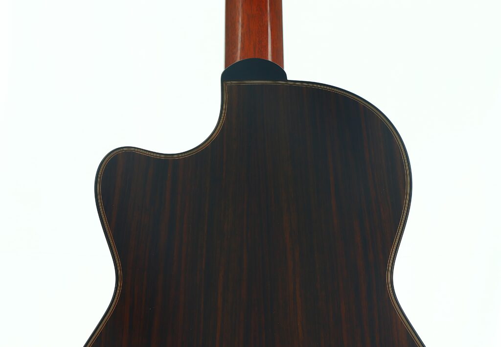 Die Rückseite der „Antonius Müller 2012 Doubletop Klassische Gitarre“ mit dunkler Holzoberfläche und sichtbarer Maserung, fotografiert vor einem schlichten weißen Hintergrund. Die Rückseite der „Antonius Müller 2012 Doubletop Klassische Gitarre“ mit dunkler Holzoberfläche und sichtbarer Maserung, fotografiert vor einem schlichten weißen Hintergrund.
